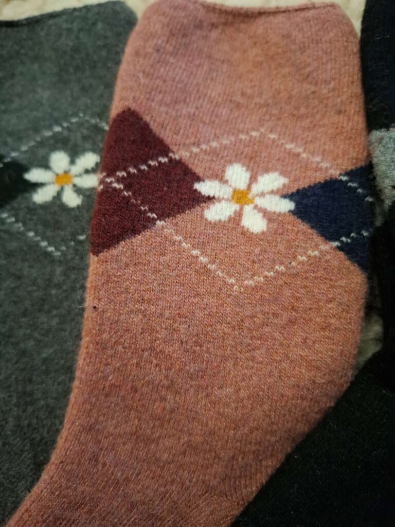 Zbliżenie wzoru kwiatka na damskich skarpetach z angory
